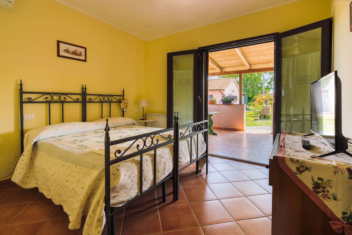 Une chambre à coucher avec un lit, un bureau et une vue sur l’extérieur.