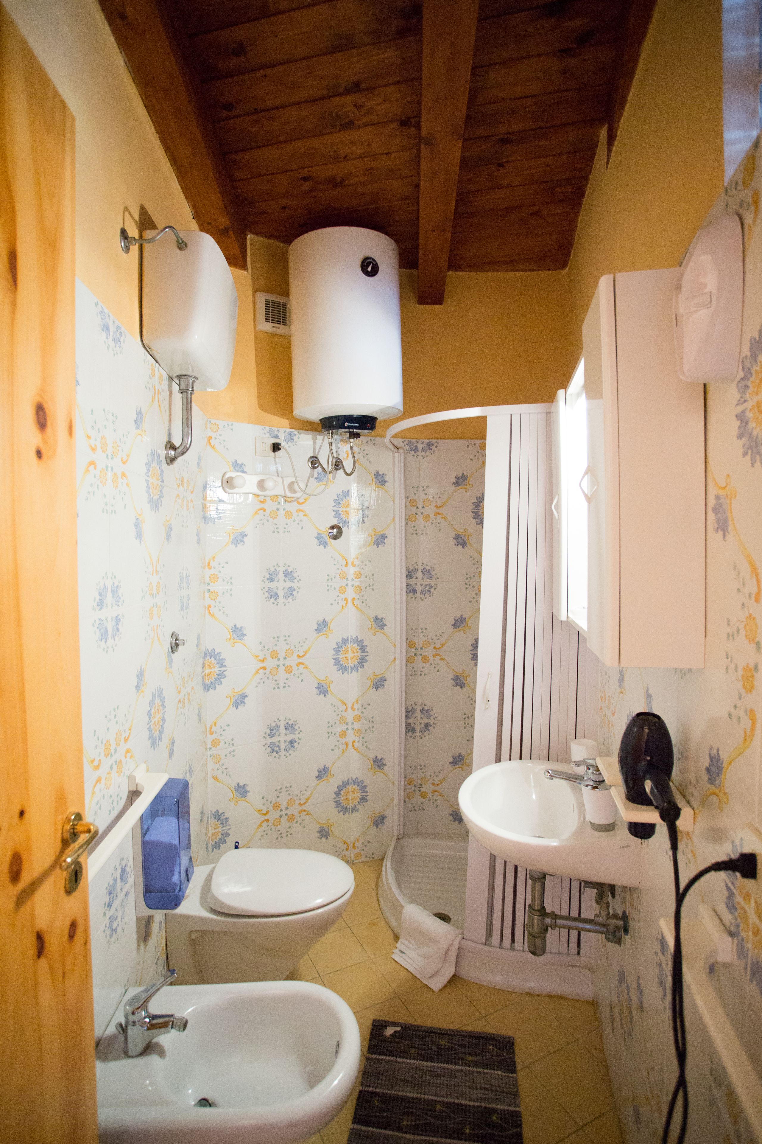A compact bathroom with a toilet, bidet, and sink.