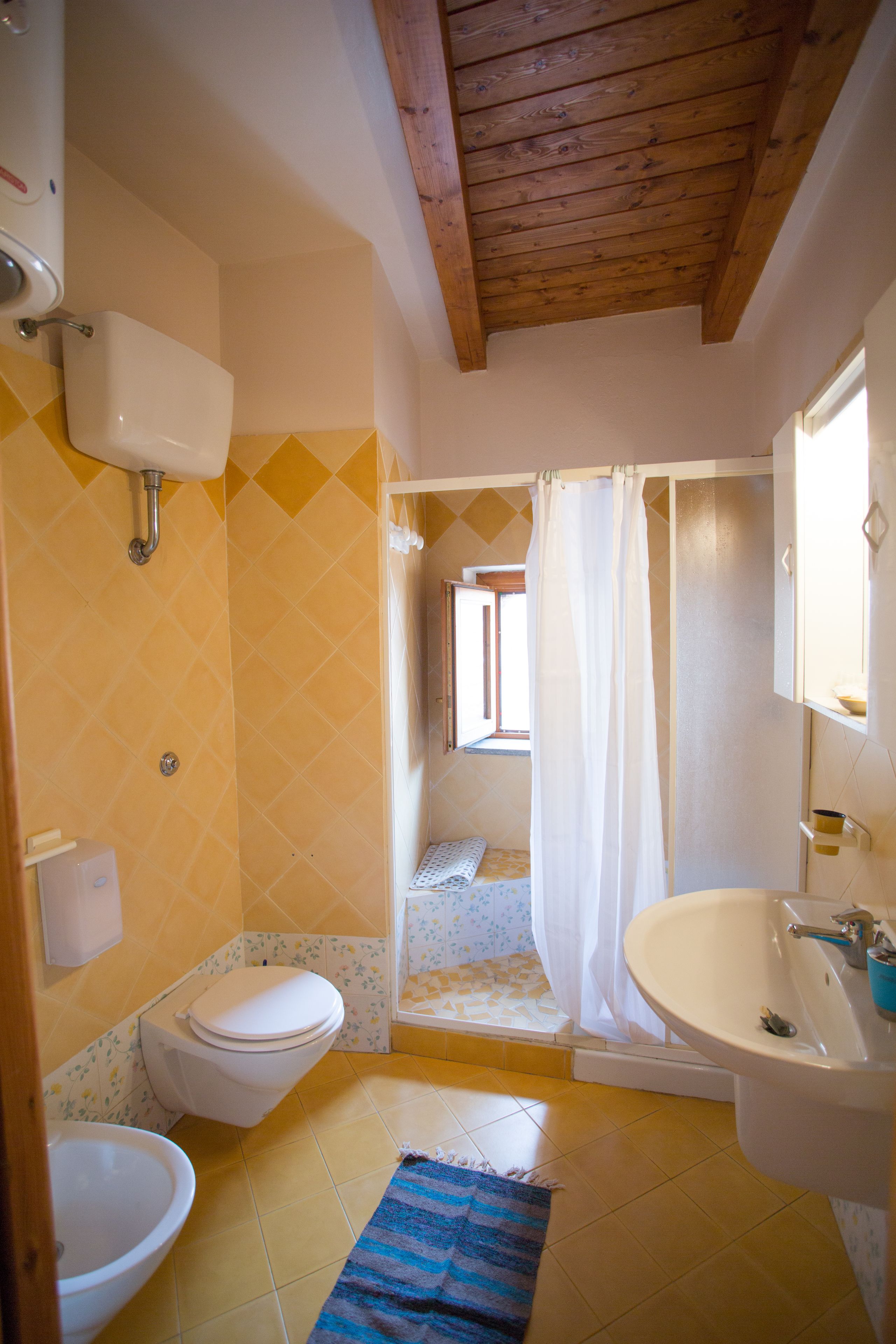 A bathroom with a toilet, sink, and shower area.