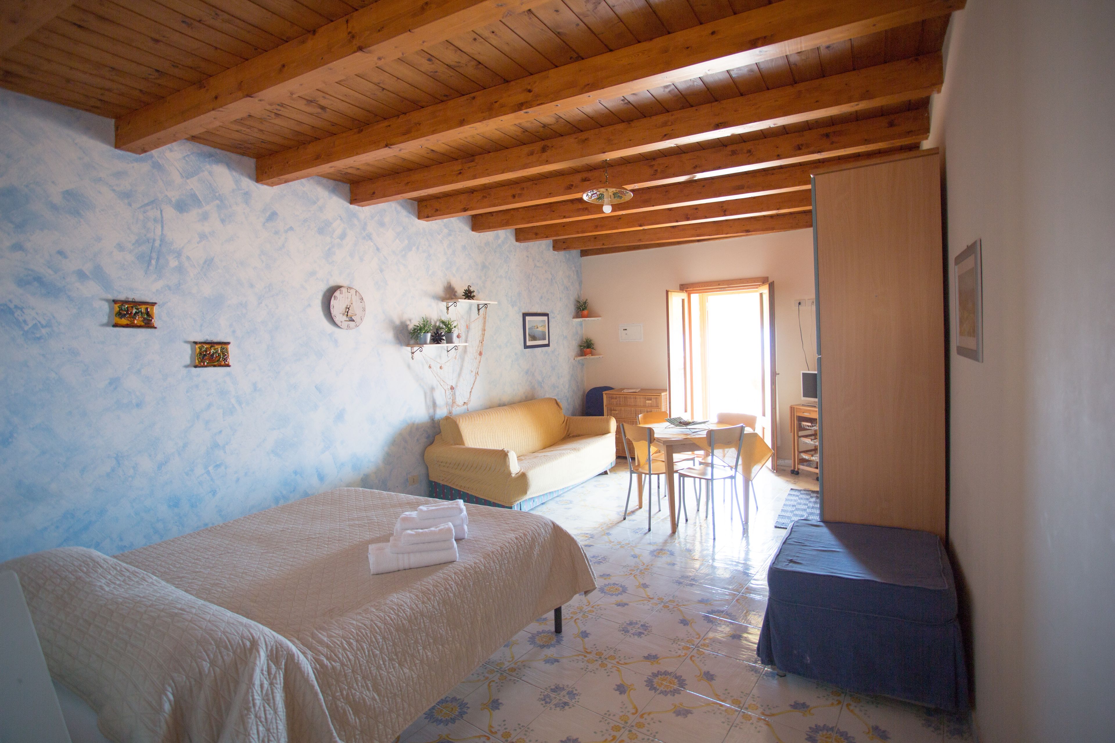Un dormitorio con cama, sofá, escritorio y silla.