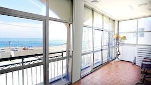 Un balcon avec vue sur l’océan et un sol carrelé.