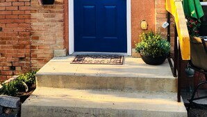 A blue door with a white frame, a small window, and a welcome mat at the entrance. - 2 Bedroom, 1 Bath Townhouse in Historic Downtown Florence! (Florence)