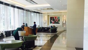 A spacious lobby with a long reception desk, seating area, and a large window with curtains. - 2 Bedroom Bellagio Towers by Stays PH (Taguig)