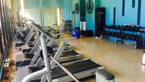 A gym with treadmills, exercise balls, and a rack of dumbbells. - 2 Bedroom Bellagio Towers by Stays PH (Taguig)