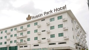 Ein mehrstöckiges Gebäude mit der Aufschrift "Austin Park Hotel" auf der Spitze.