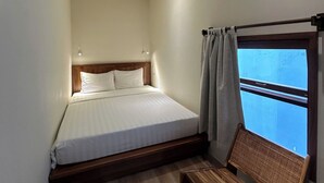 A bedroom with a bed, a ceiling fan, an air conditioning unit, a window with curtains, and a wooden bench. - Soleil House (Hue)