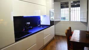 A modern kitchen with white cabinets, a black countertop, and a built-in oven. - GREAT APARTMENT IN CASCO ANTIGUO (Sevilla)