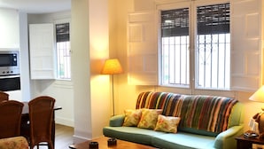 A living room with a green sofa, patterned armchairs, a wooden coffee table, and a lamp. - GREAT APARTMENT IN CASCO ANTIGUO (Sevilla)
