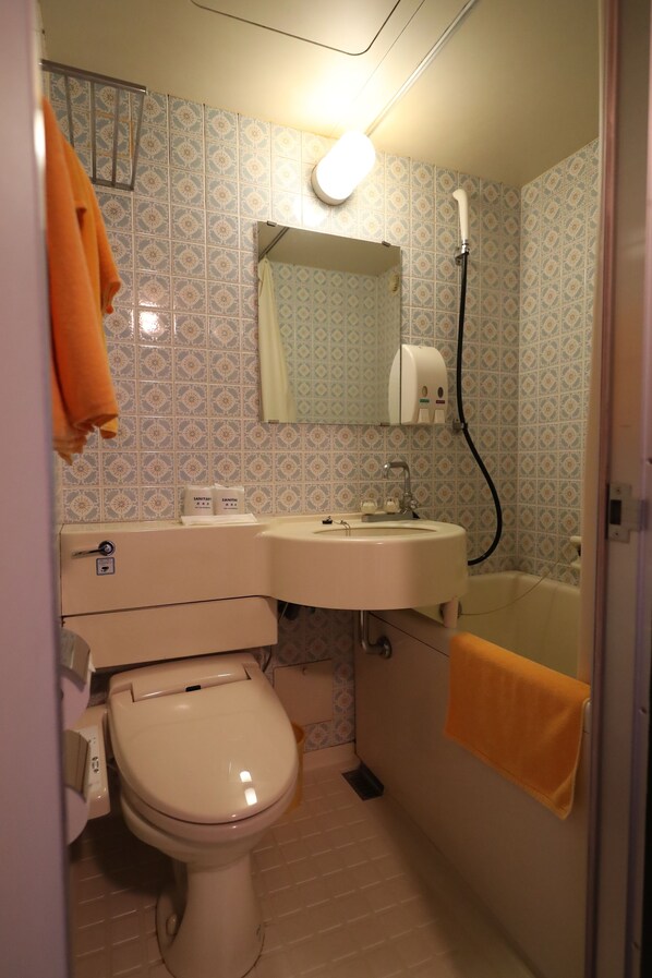 Un baño con inodoro, lavamanos y ducha.