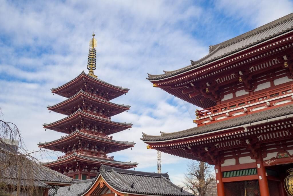 A traditional Japanese pagoda with multiple tiers and a red gate.