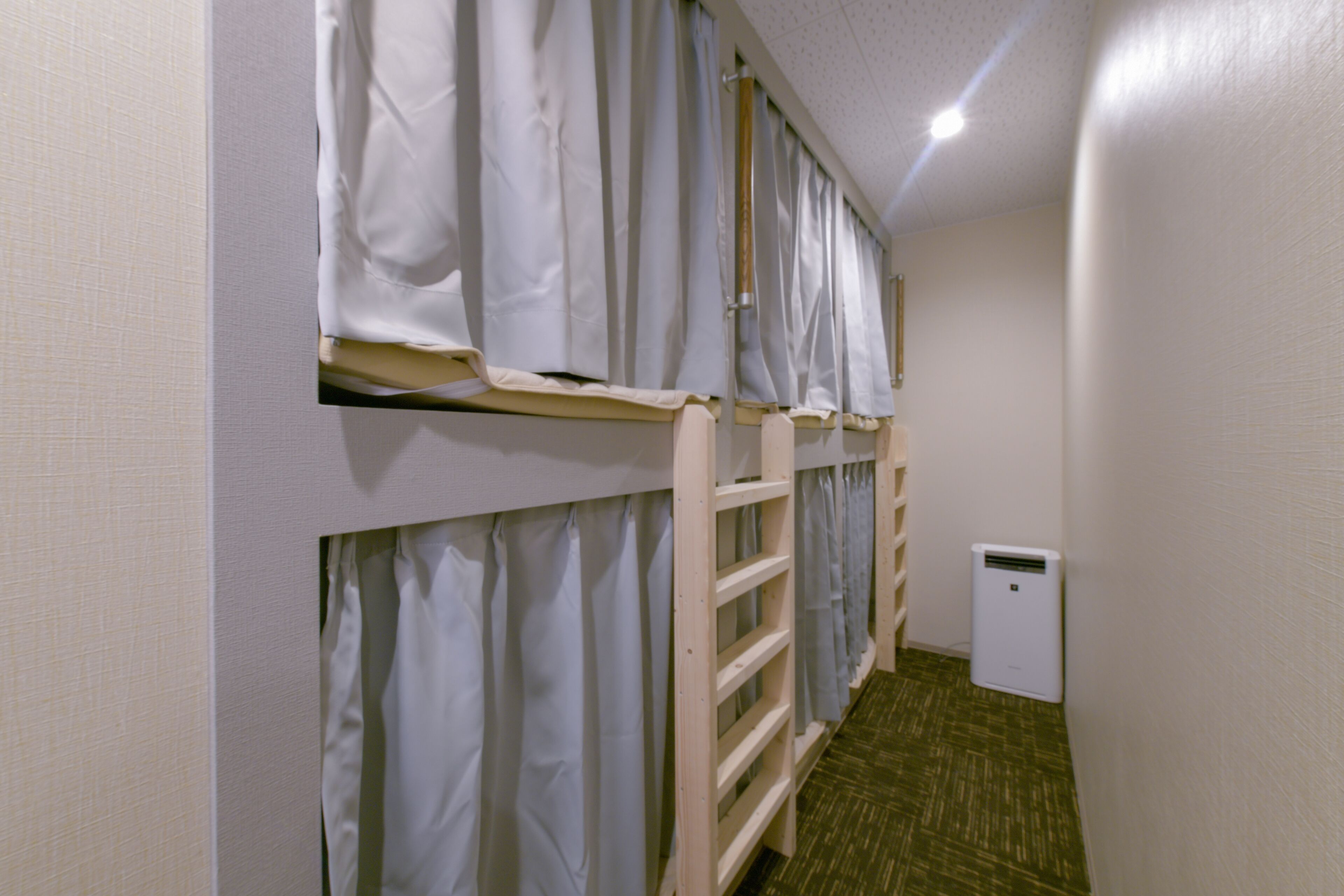 A narrow hallway with bunk beds, a small heater, and a door.