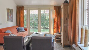 A living room with a sofa, chairs, a table, and a cabinet. - Amazing home in Hoge Hexel with WiFi (Hoge Hexel)