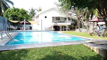 Una piscina al aire libre, sombrillas