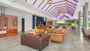 Un vestíbulo amplio con techo alto, muebles modernos y vistas al exterior.