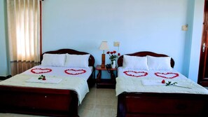 Habitación cuádruple Deluxe | Escritorio, cortinas blackout, wifi gratis y ropa de cama 