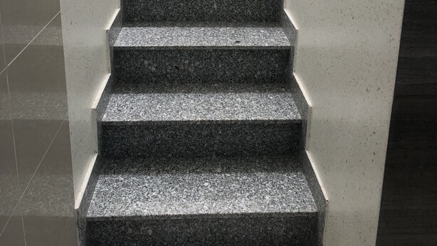 A staircase with granite steps and a metal railing, leading to an upper floor. - Queen Hotel 3 (Nha Trang)