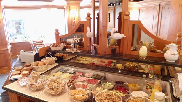 Un bufé con diferentes opciones de comida y una estación de café.