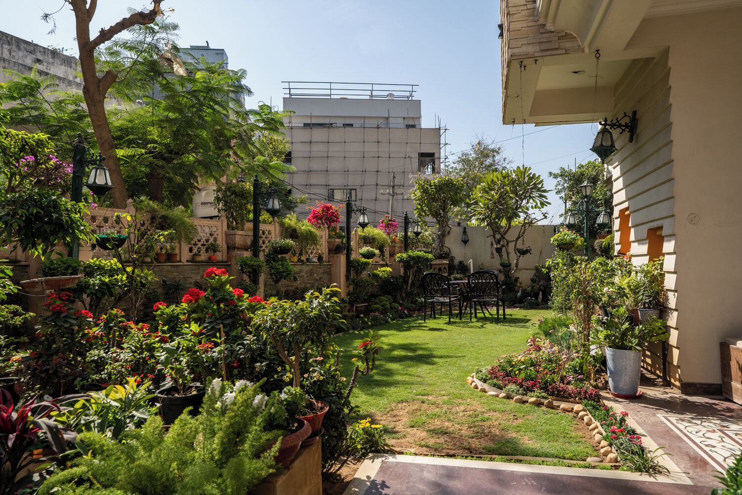 Jardí ben cuidat amb gespa, plantes en testos i zona de seients.