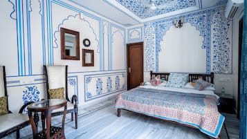 Un dormitorio con una cama, una silla, un espejo y una puerta.