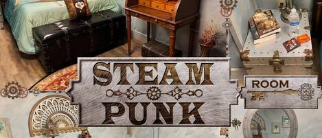 A room with a bed, a red sofa, a wooden desk, and a vintage-style mirror.
