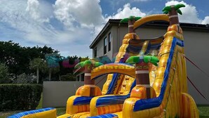 A large inflatable slide with a jungle theme, including a slide, a pool, and a slide ladder.