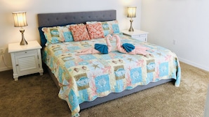 A neatly made bed with a quilt, two bedside lamps, and a nightstand with a lamp. - Perfect Vacation Getaway-Modern Gated Community, Spacious, Pool, Game Room, WiFi (Davenport)