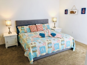 A neatly made bed with a quilt, two bedside lamps, and a nightstand with a lamp.