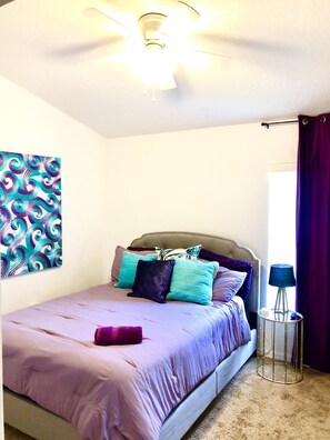 A bedroom with a bed, a ceiling fan, a nightstand, a lamp, and a window with curtains. - ★ 5-STAR LUXURY ★ Modern Gated Haven, Private Pool, Game Room, Near Disney  (Davenport)