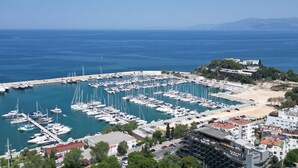 A marina with numerous boats docked, surrounded by buildings and a beach. - ADELLA GARDEN MARİNA HOTEL (Kusadasi)
