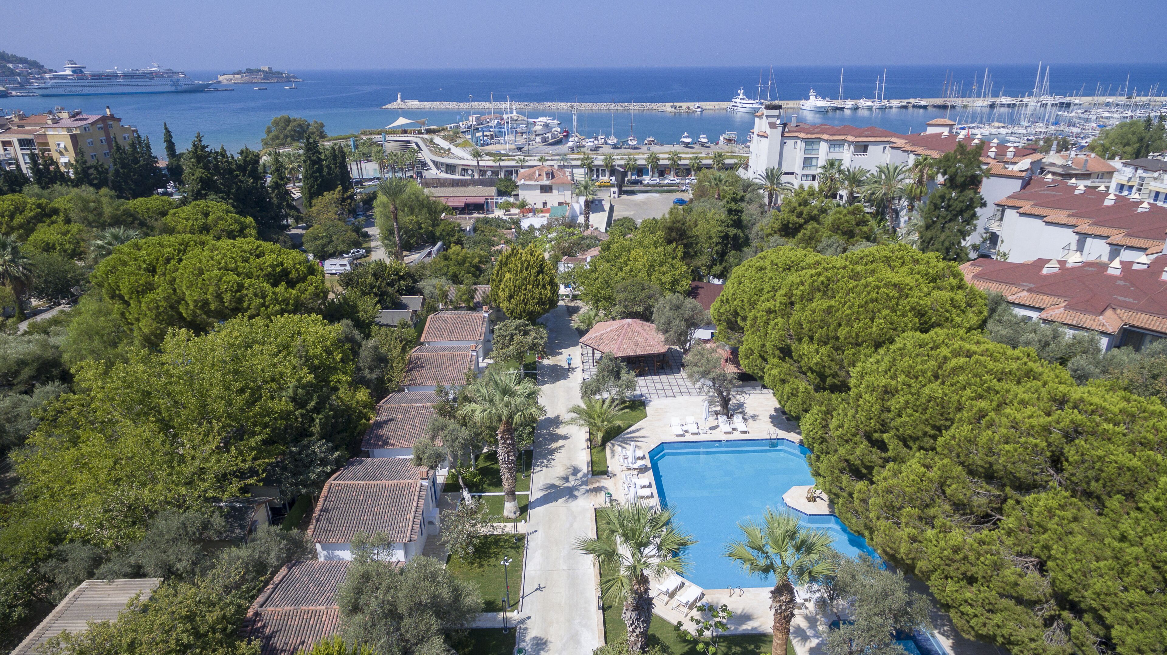 Een kustresort met een zwembad, villa's direct aan het strand en een jachthaven.