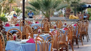 An outdoor dining area with wicker chairs and tables covered with blue and white checkered tablecloths. - Maritim Jolie Ville Resort & Casino (SHARM EL SHEIK)