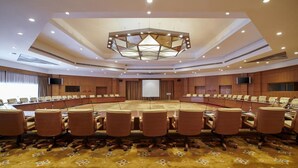 A conference room with a large oval table, multiple chairs, a central podium, and a ceiling light fixture. - Maritim Jolie Ville Resort & Casino (SHARM EL SHEIK)