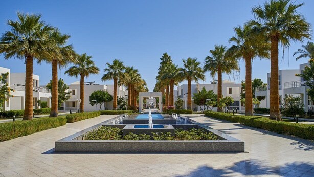 A courtyard with a central water feature, surrounded by palm trees and modern buildings. - Maritim Jolie Ville Resort & Casino (SHARM EL SHEIK)