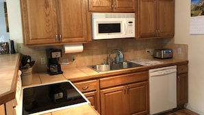 A kitchen with wooden cabinets, a microwave, a toaster, a sink, and a dishwasher. - Ketchikan Northern Retreat - 3 Bedroom Apartment on Large Private Lot (Ketchikan)