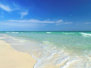Una spiaggia con acque cristalline e una riva sabbiosa.