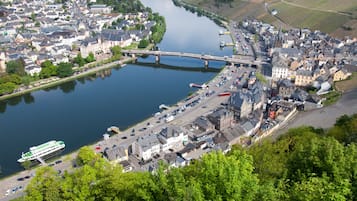 Een pittoresk stadje aan de rivier met een brug, historische gebouwen en een bootsteiger.