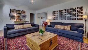 A living room with two dark blue sofas, a wooden coffee table, and a patterned rug.