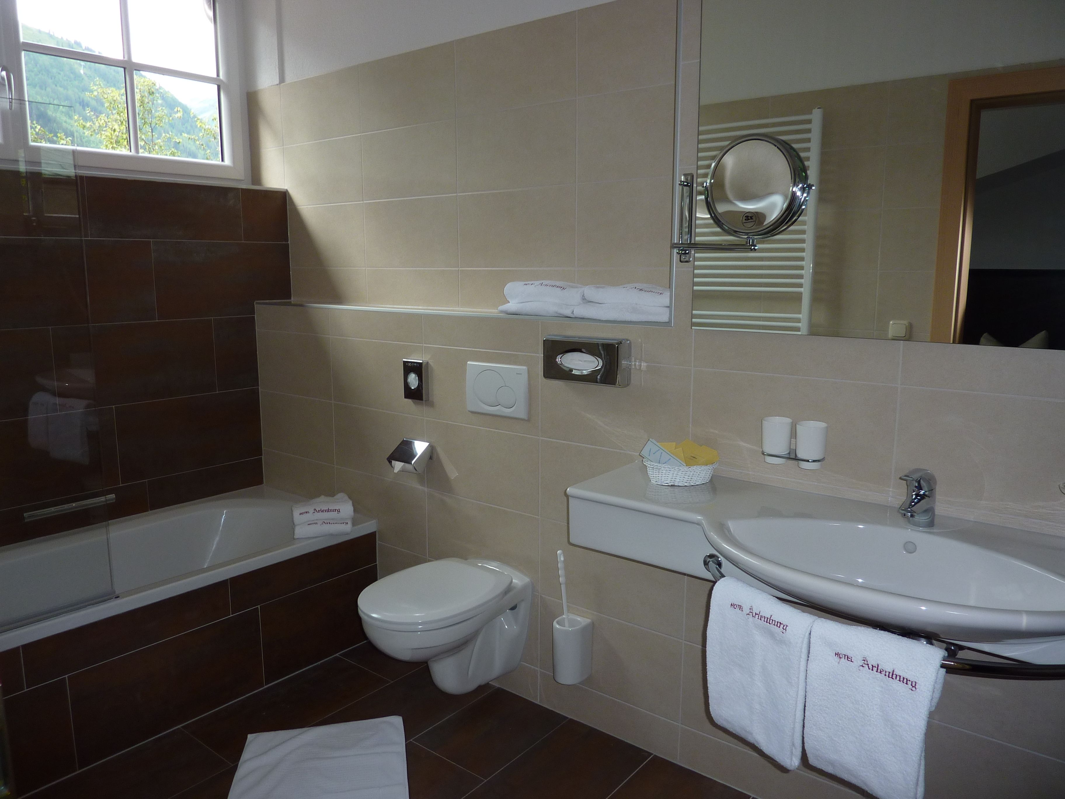 Une salle de bain moderne avec une baignoire, des toilettes et un lavabo. On peut voir des serviettes et des articles de toilette.