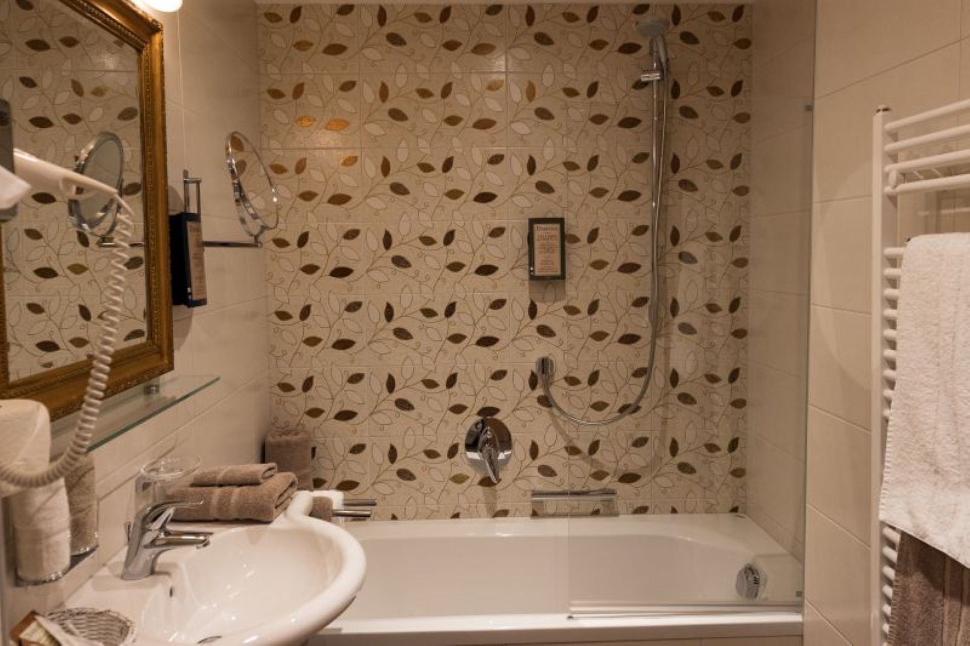 A bathroom with a bathtub, a sink, a mirror, and a shower.