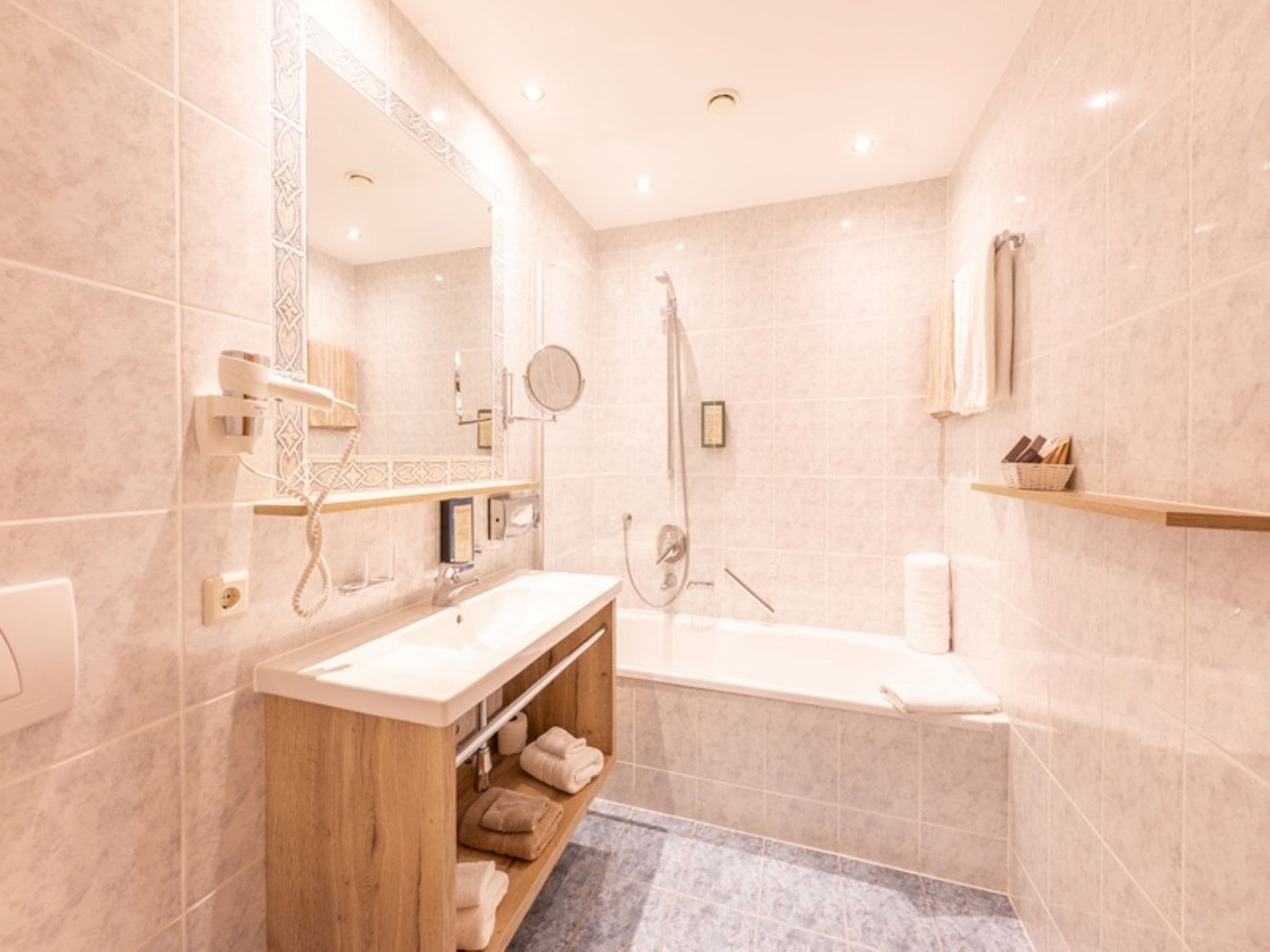 Une salle de bain moderne avec un meuble-lavabo en bois, une baignoire et une douche.
