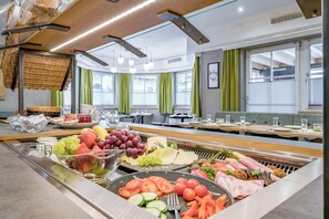 Un bufé con diversas frutas, verduras y carnes.