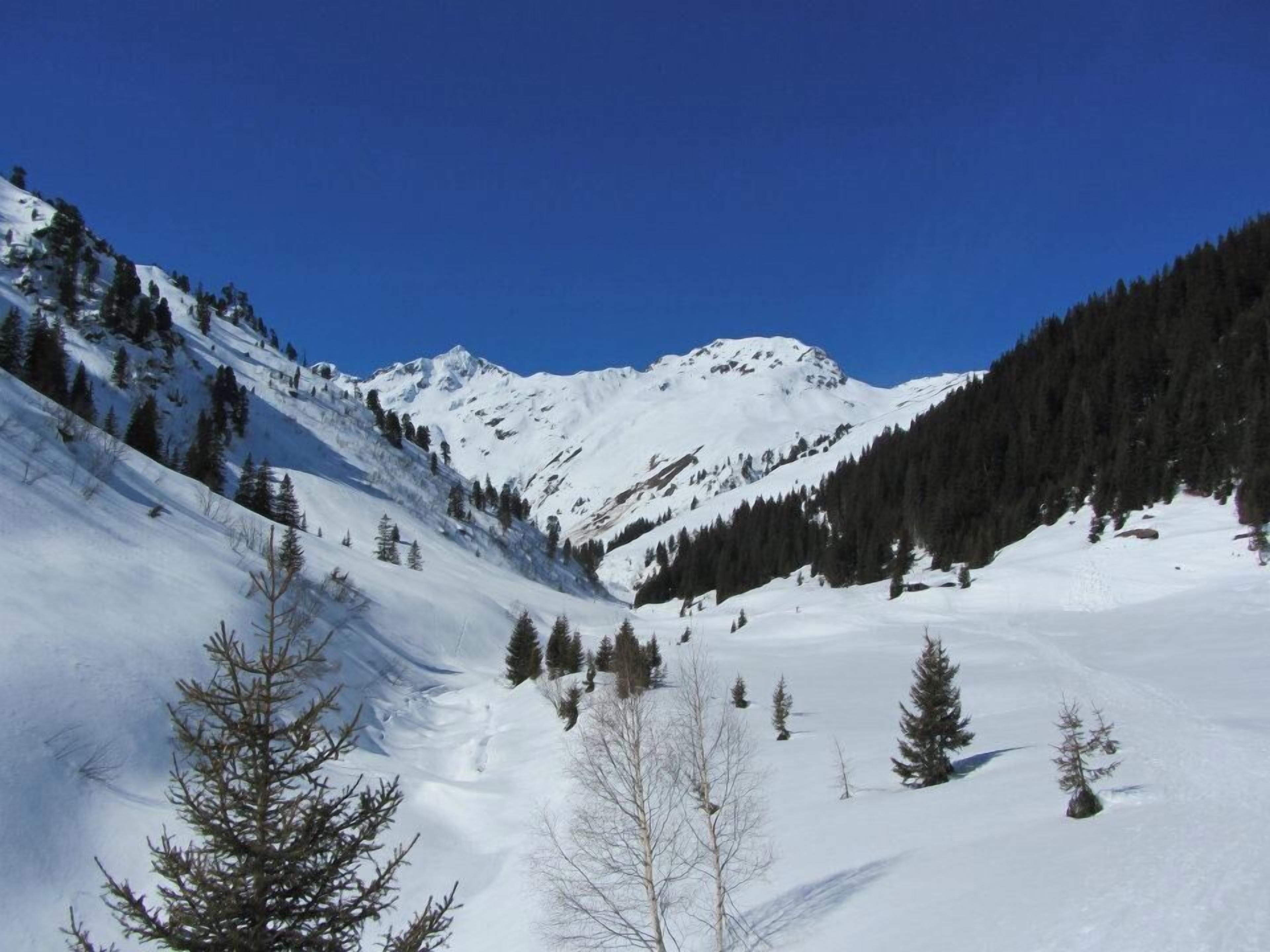 A snow-covered mountain landscape with clear skies.