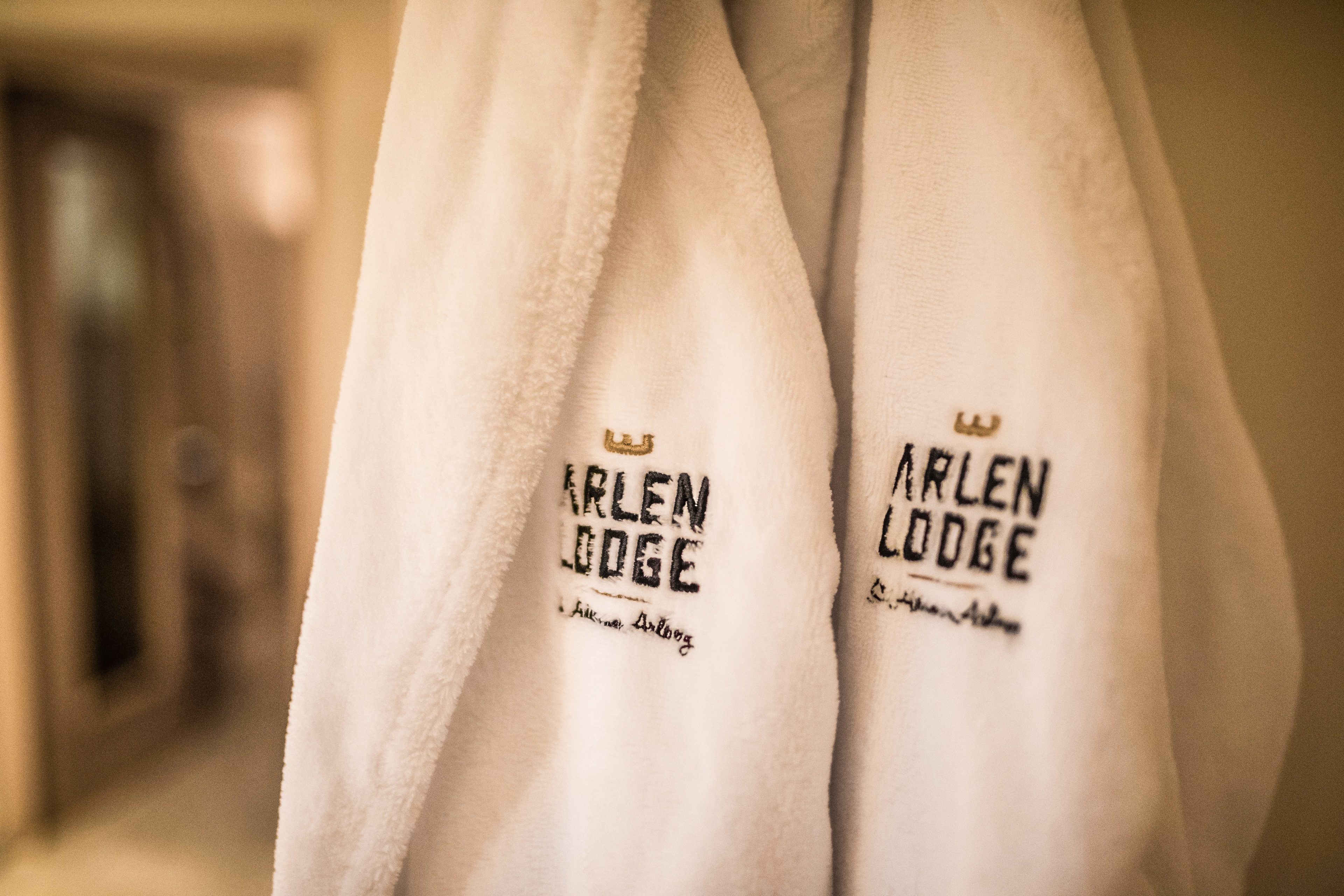 Ein Handtuchpaar mit dem Aufdruck 'ARLEN LODGE' und einem Kronensymbol.