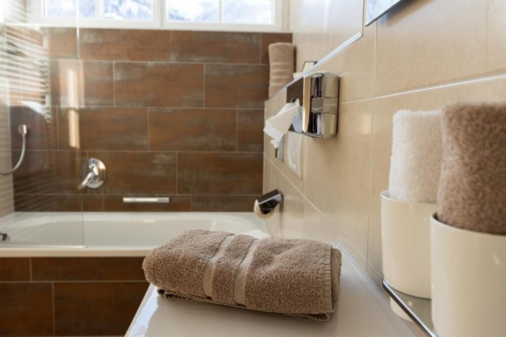 Un baño con bañera, toallero y ventana.