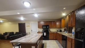 Una cucina moderna con mobili in legno, un'isola centrale e un forno a microonde integrato.