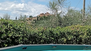 Une piscine offrant une vue sur une colline et des bâtiments en arrière-plan.