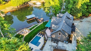 An aerial view of a house with a swimming pool, dock, and lush greenery. - Huckleberry Hideout by SoCharm | Private Cabin Oasis (Mooresville)