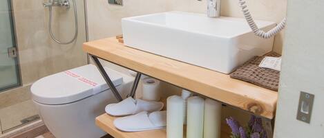 A modern bathroom with a shower, toilet, and sink.