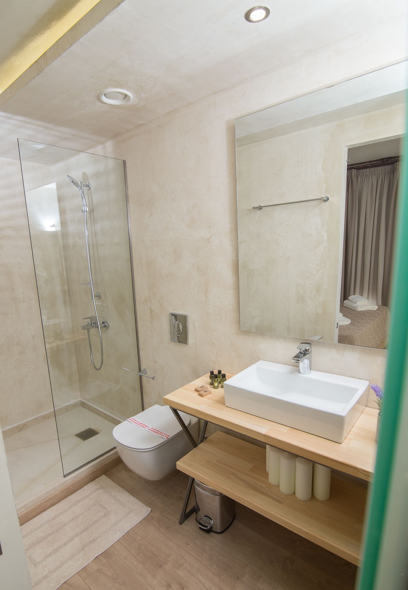Une salle de bain moderne avec une douche à parois de verre, un lavabo blanc et un grand miroir.