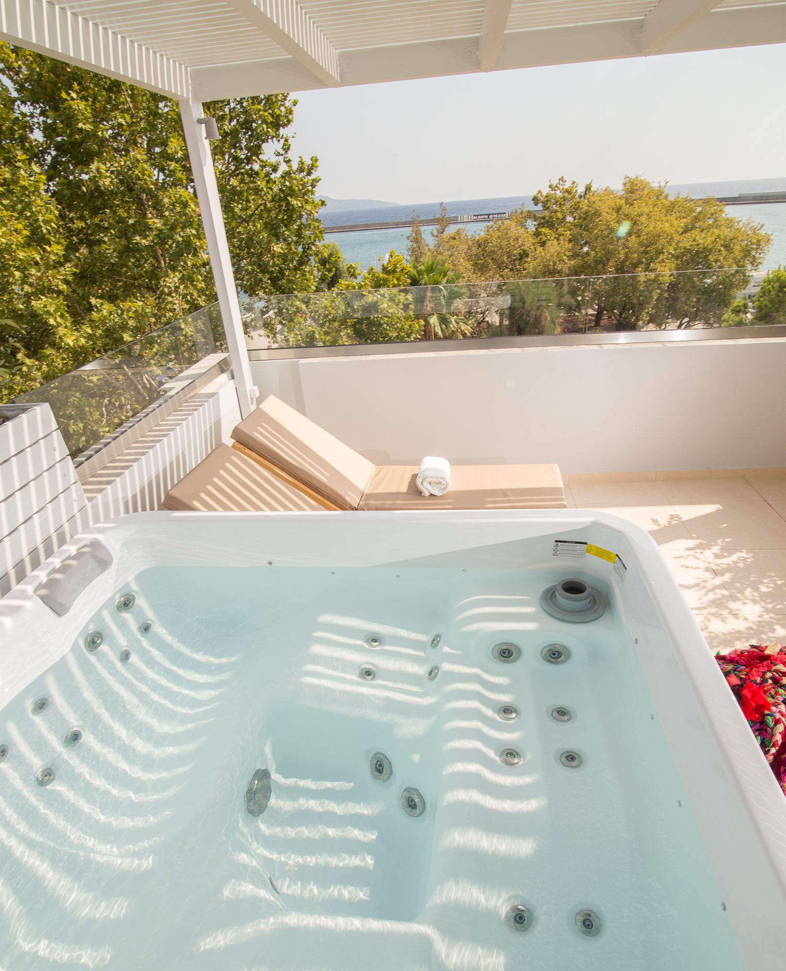A hot tub with a view of the sea and trees.